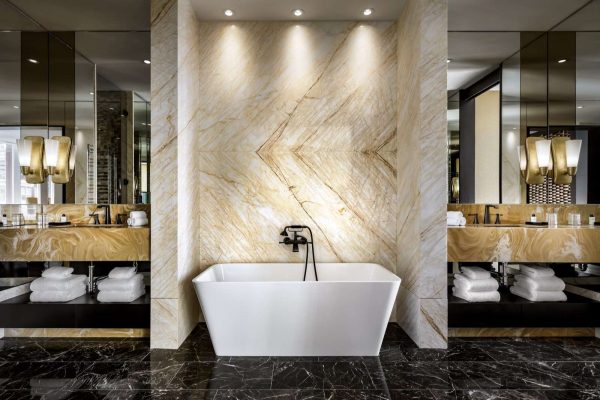 the-bisha-suite-bathroom-features-a-large-shower-tub-and-two-vanitiesall-wrapped-in-golden-spider-marble